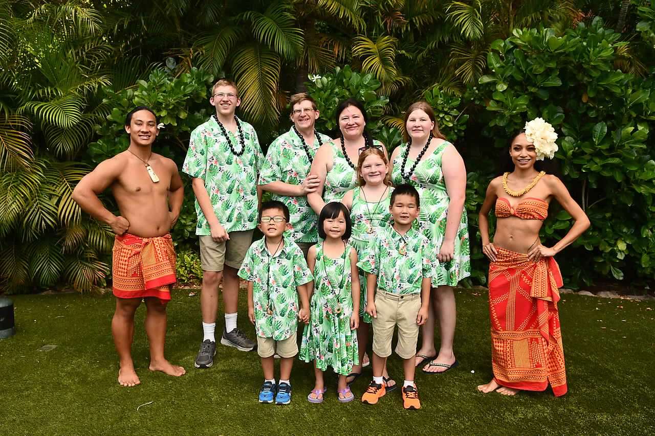 family dessed in coordinating mickey island clothes with hoola dancers at aluani lual