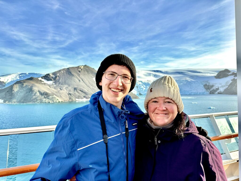 mother and son on cruise with beautiful chillean fjords from chile south america in the background