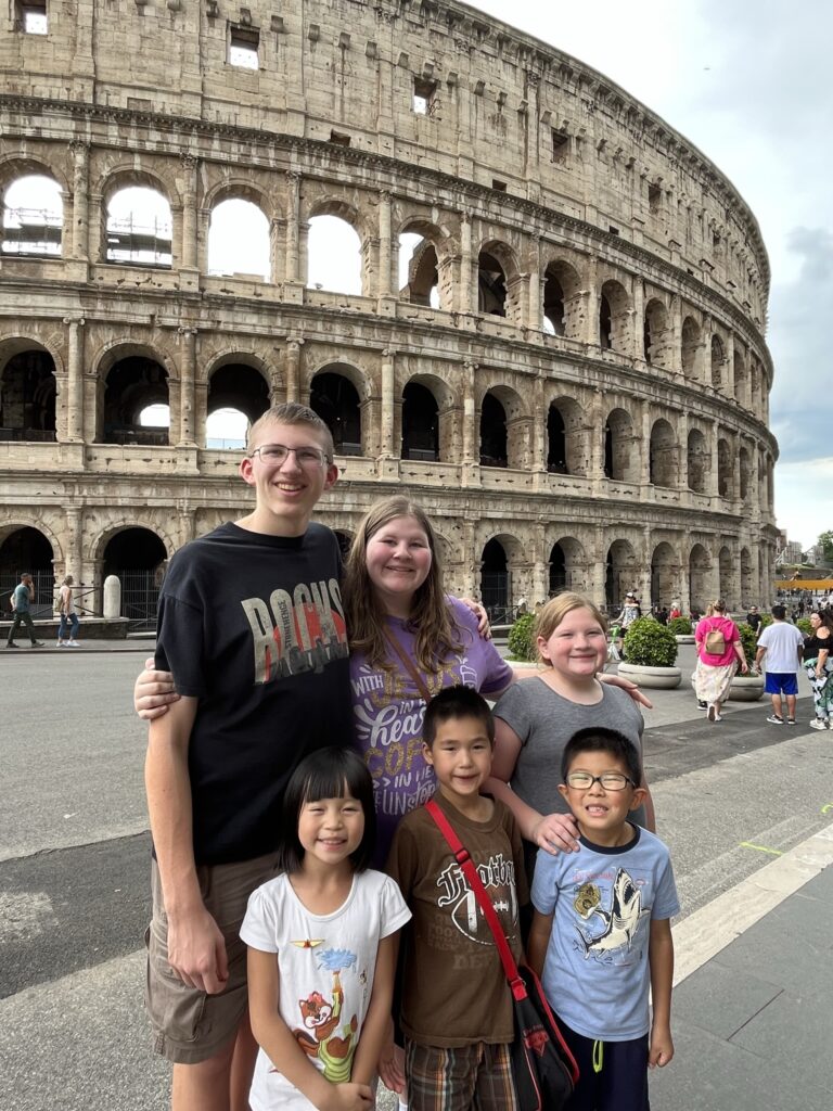 family visiting the Roman Colosseum in rome italy on family vacation in Europe