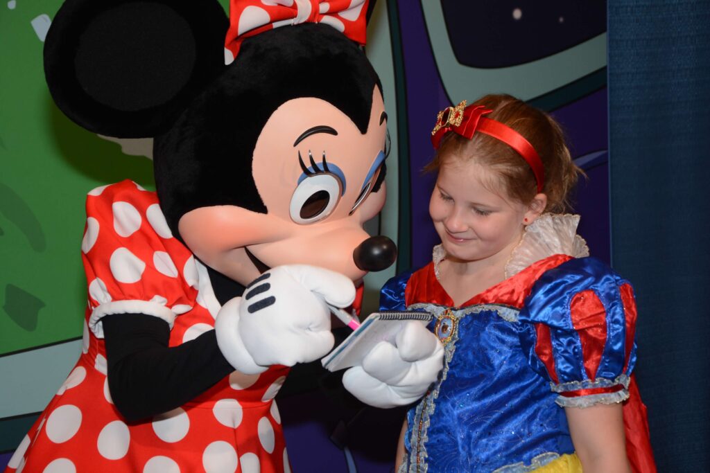minne giving autograph to girl dressed as snow white