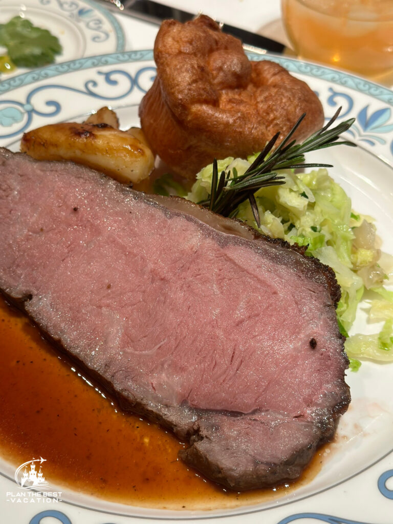 King George's Roasted Privateer Strip Loin with thyme roasted potaotes, buttered savory cabbage, yorkshire pudding, and a Rosemary wine sauce