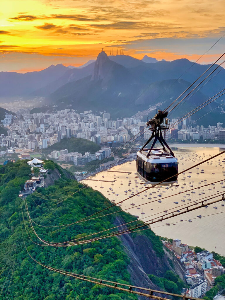 Sugarloaf mountain cable car during sunset in Rio de Janeiro, with Christ the Redeemer statue in the background