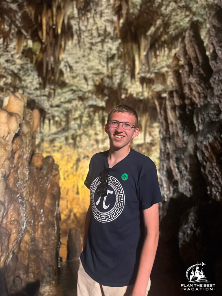boy in Drogarati Cave Argostoli Greece showing backdrop of dramatic stalactites and stalagmites
