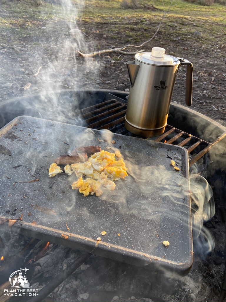 cooking breakfast over a firepit with coffee eggs and sausage