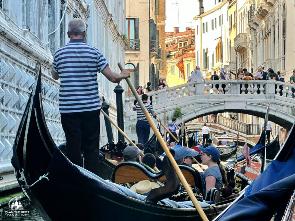 crowded cananl with line of gondoliers in venice, italy