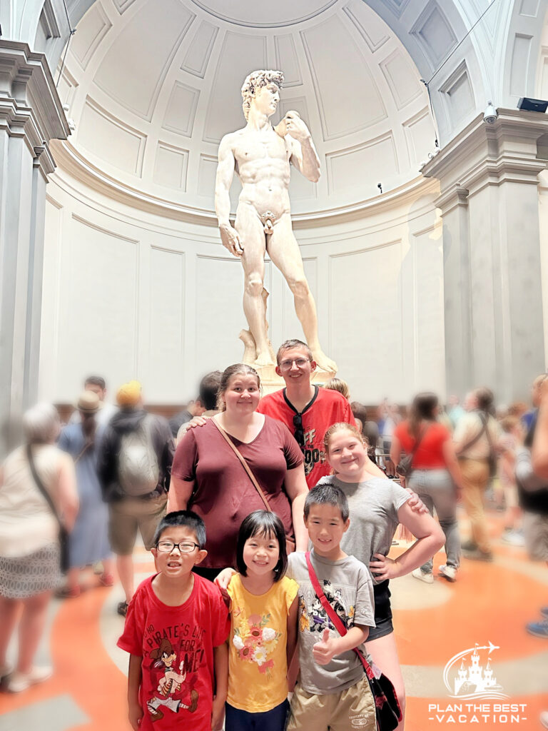 family standing in front of michaelangelo david statue in florence italy museum