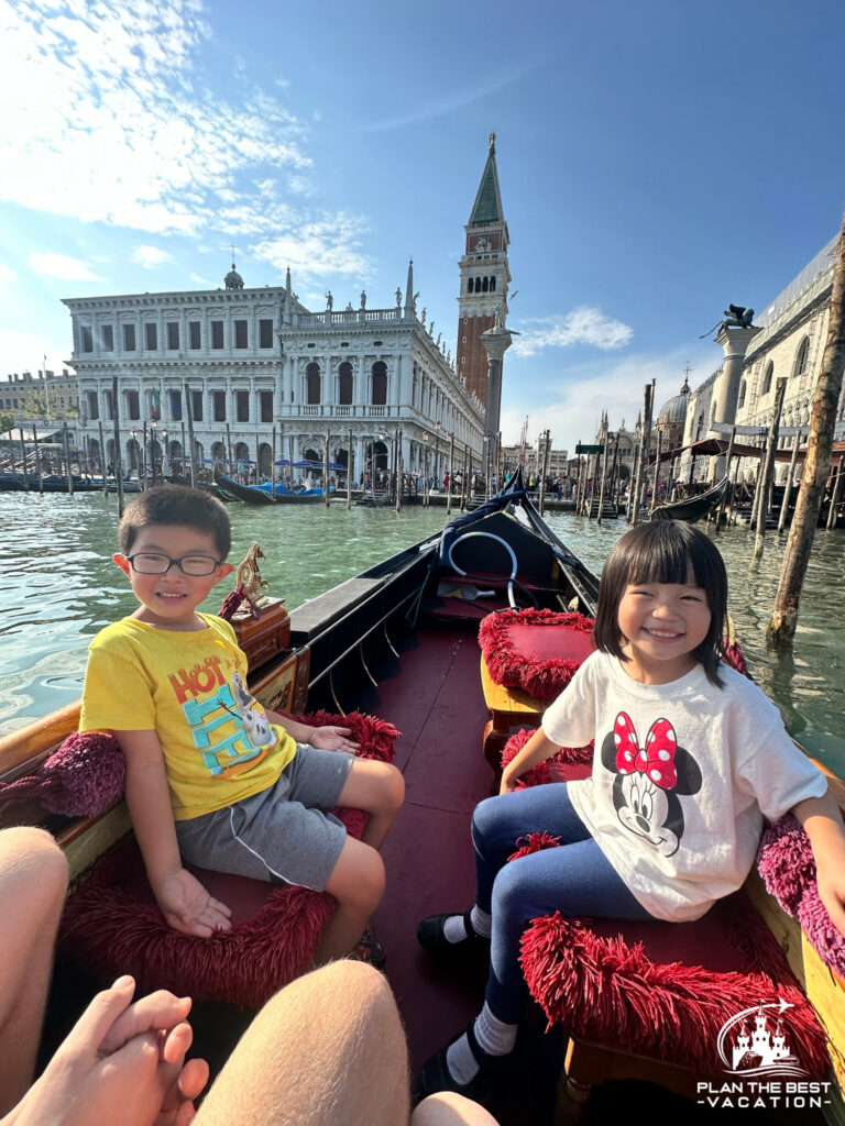 kids on a gondola ride through canals in venice italy